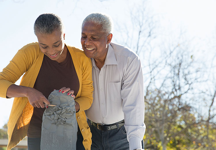 Man looking over a womans shoulder at a piece of art