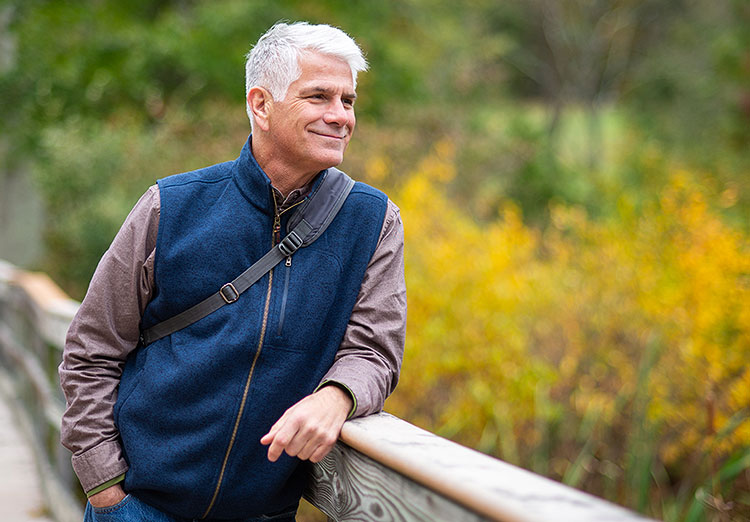 Image of a man on a bridge looking into the woods