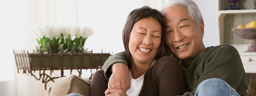 Two people hugging on a couch.