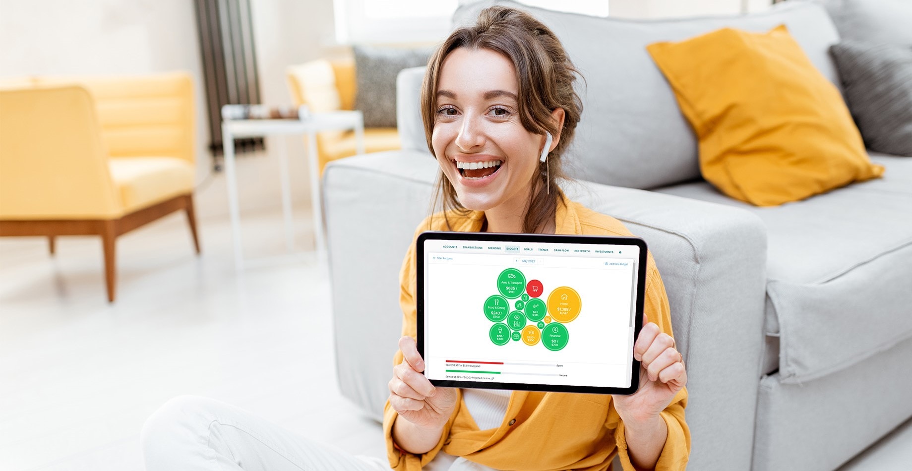 Woman smiling and showing off tablet which shows budget screen of WellnessPATH platform.