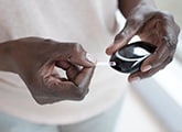 hands holding glucose measuring device
