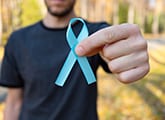 man holding blue ribbon - signaling support for prostate cancer awareness