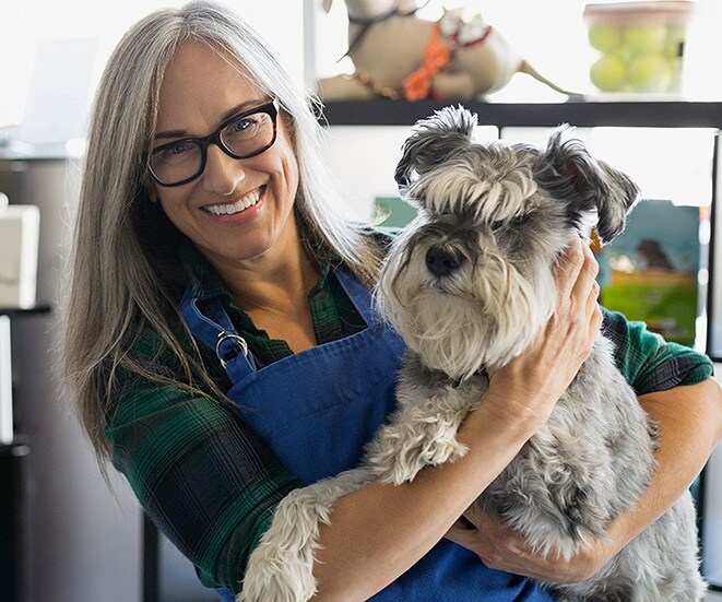 Lady holding dog smiling.