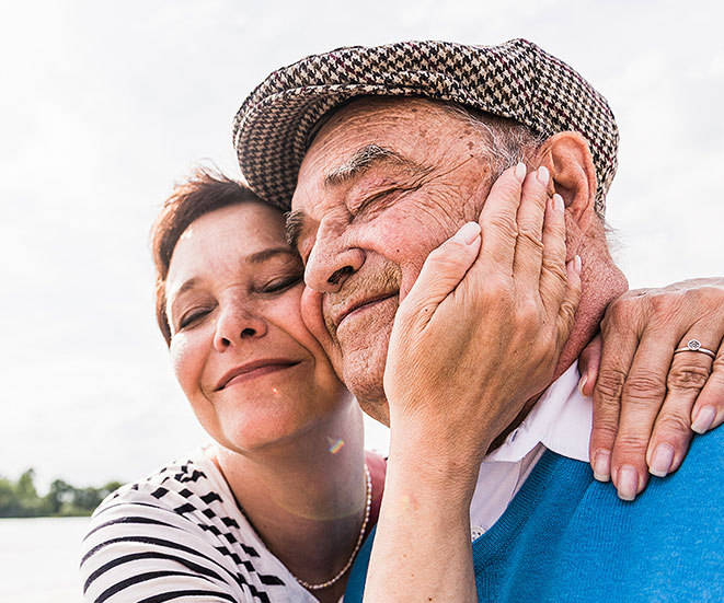 A daughter and father smiling while holding each other.