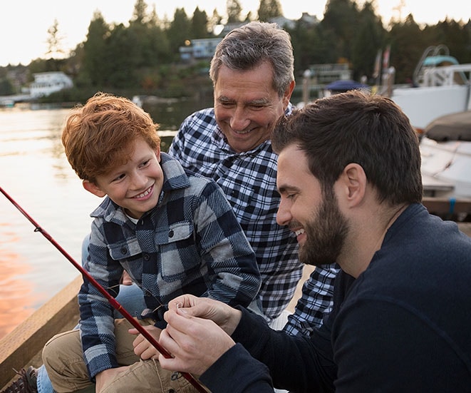 A father and grandfather teaching the son to fish. 