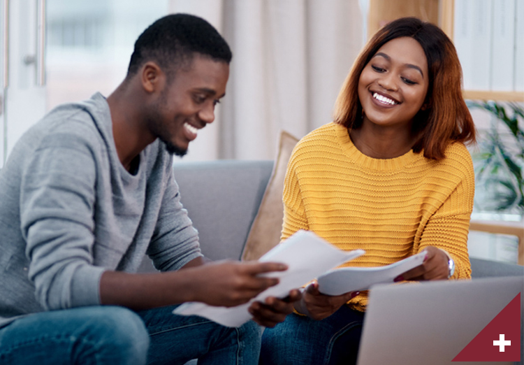 Young couple sit and smile as they go through documents