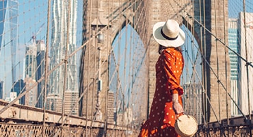 woman standing on and looking up at the Brooklyn Bridge