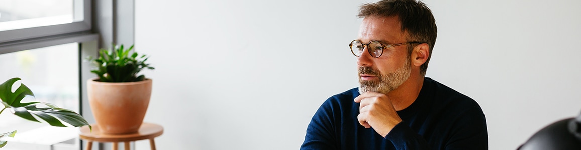 man sits in chair and looks off to the left