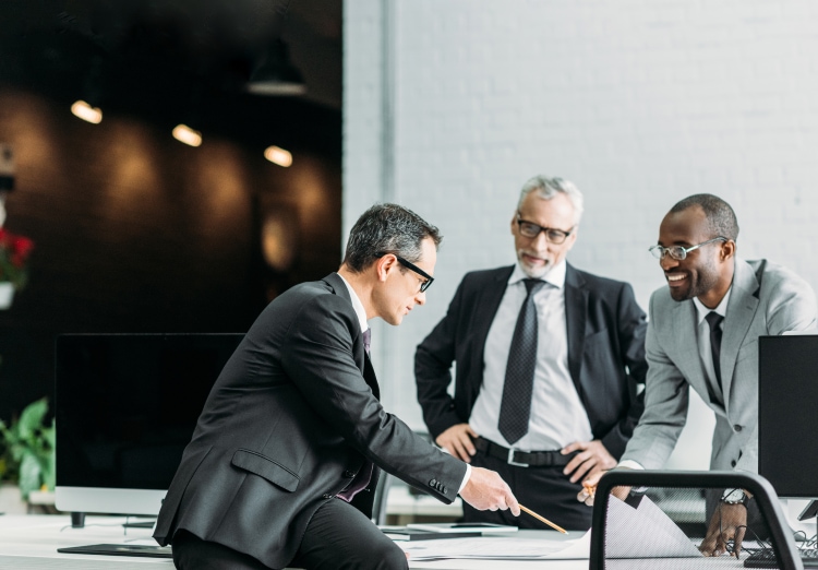 Men in suits review plans over a desk