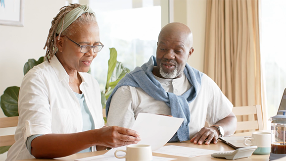 Couple looks at documents while sitting at kitchen table