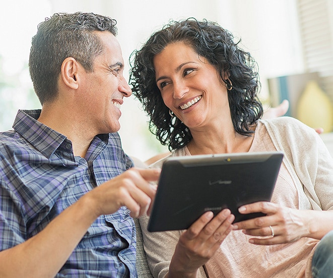 Two people looking at a handheld device.