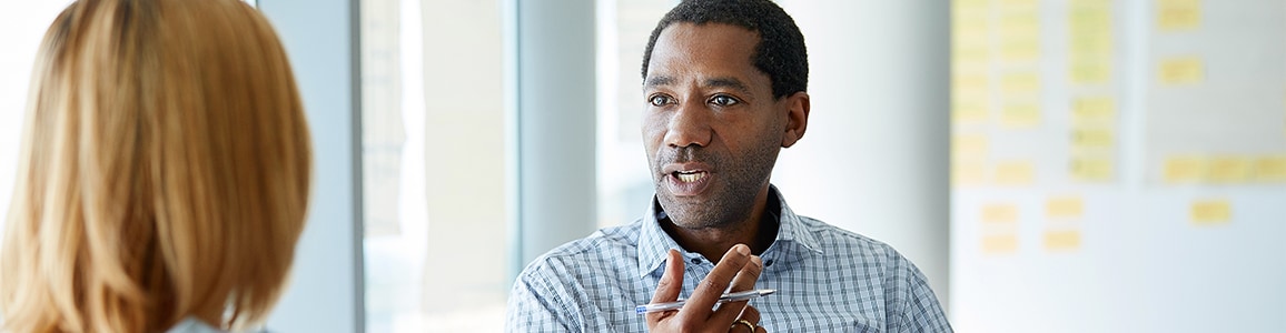 Man talking to his colleague in a modern office