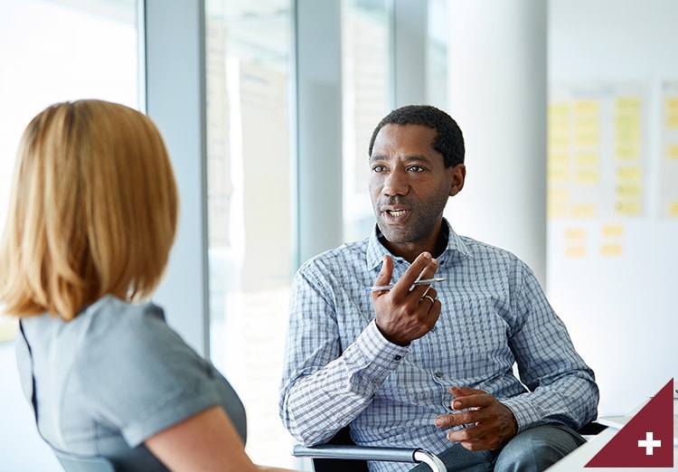 Man talking to his colleague in a modern office