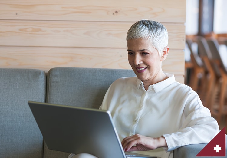 Senior business woman working on laptop at a café lounge