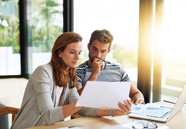Man and woman sit next to each other and look at documents