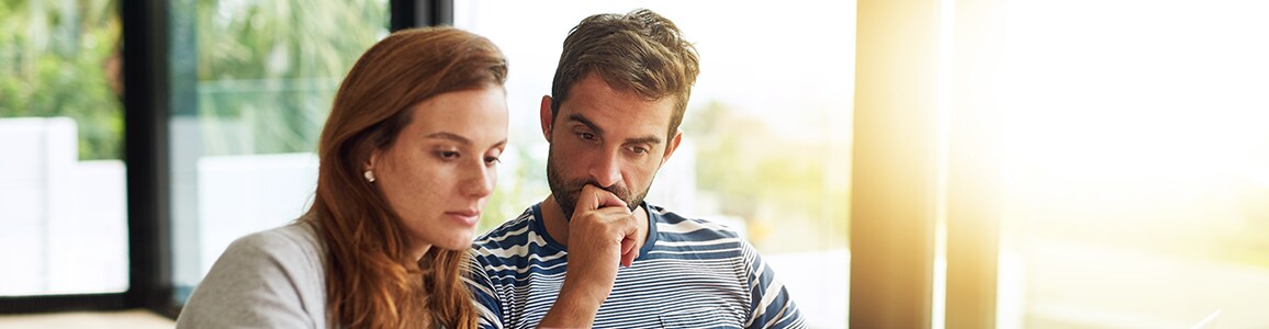 Man and woman sit next to each other and look at documents