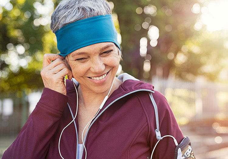Smiling woman with headphones wearing a turquoise headband