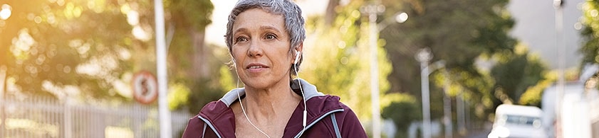 Woman wearing headphones walking on a street