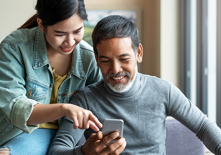 man and woman looking at smart phone