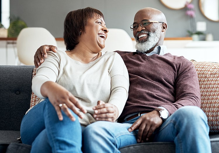 couple sitting on couch and laughing