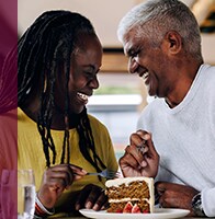 couple laughs while sharing a slice of cake