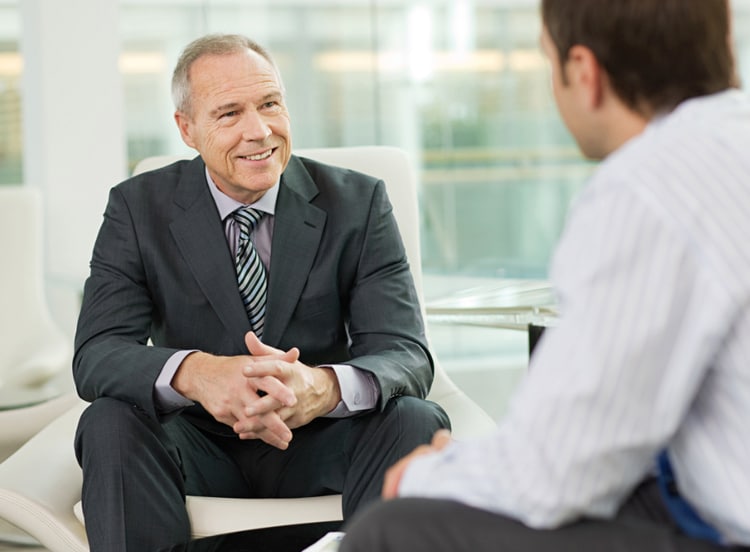 men sitting in chairs talking