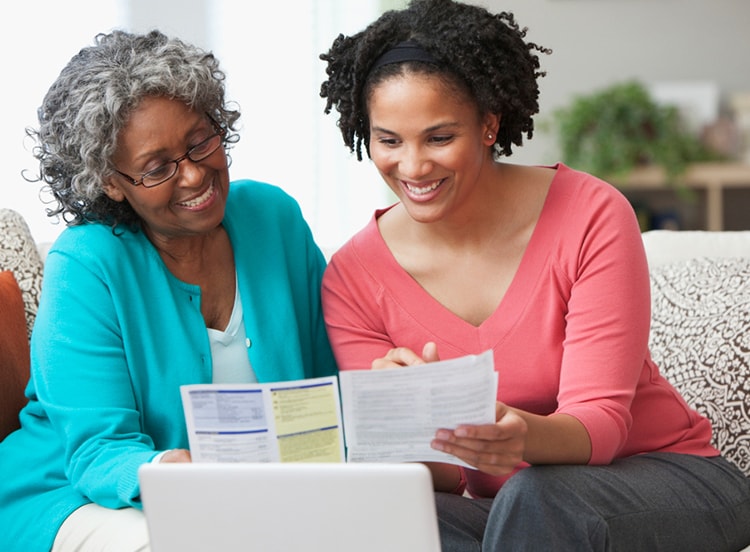 women sitting on couch reviewing documents