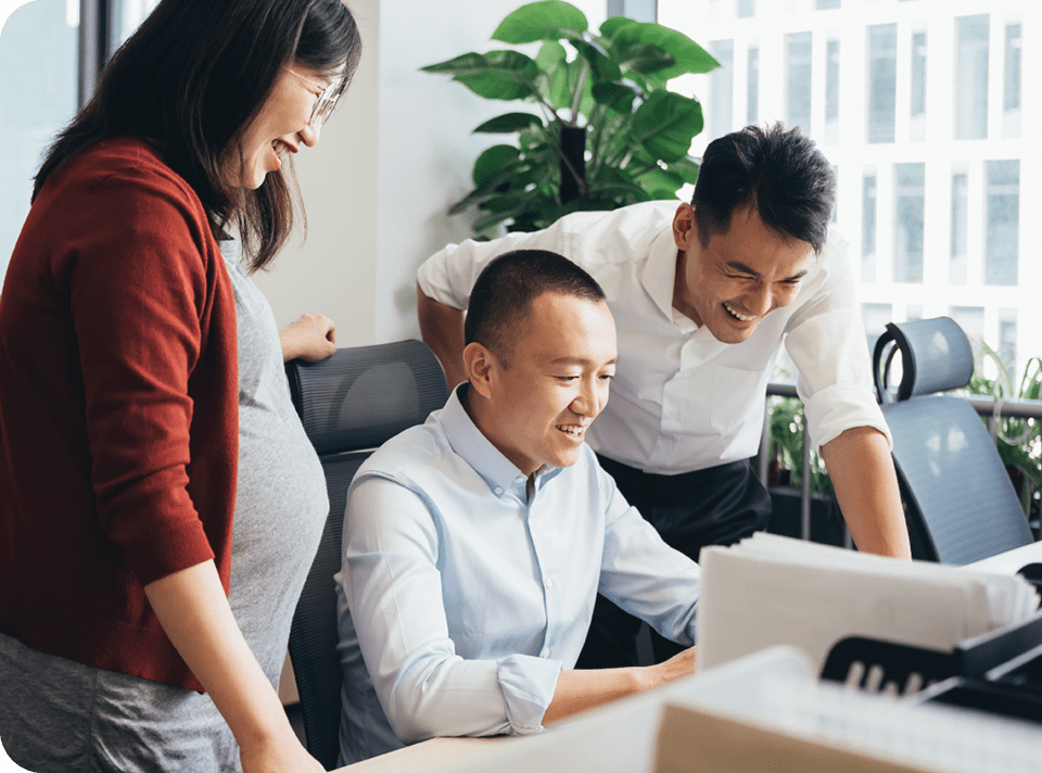 coworkers in an office looking at a computer