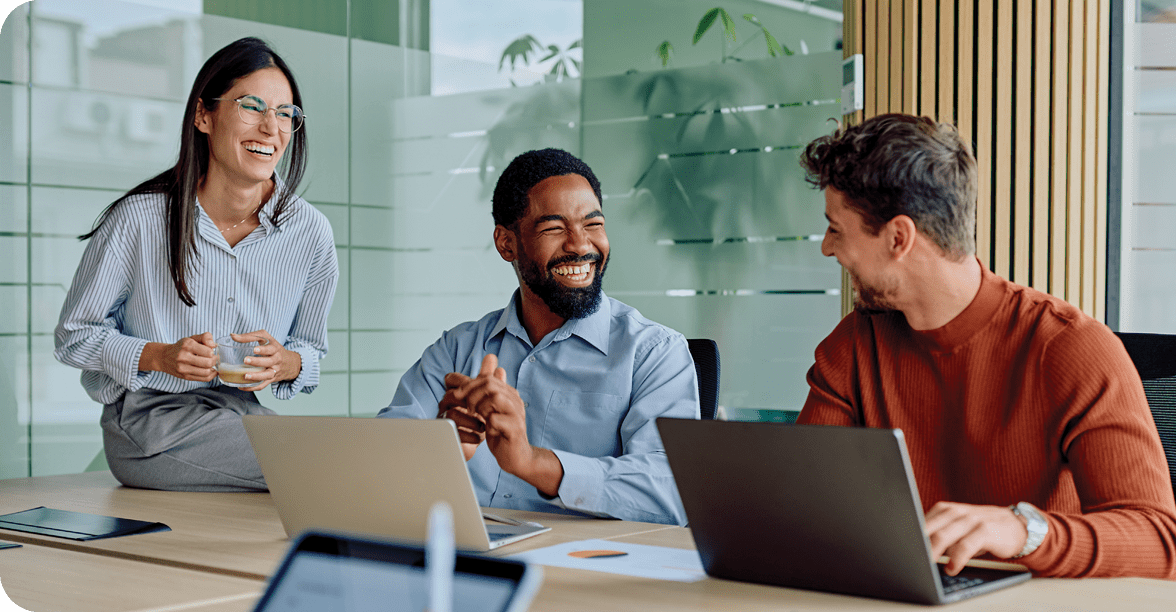 Diverse business team collaborating and laughing during office meeting