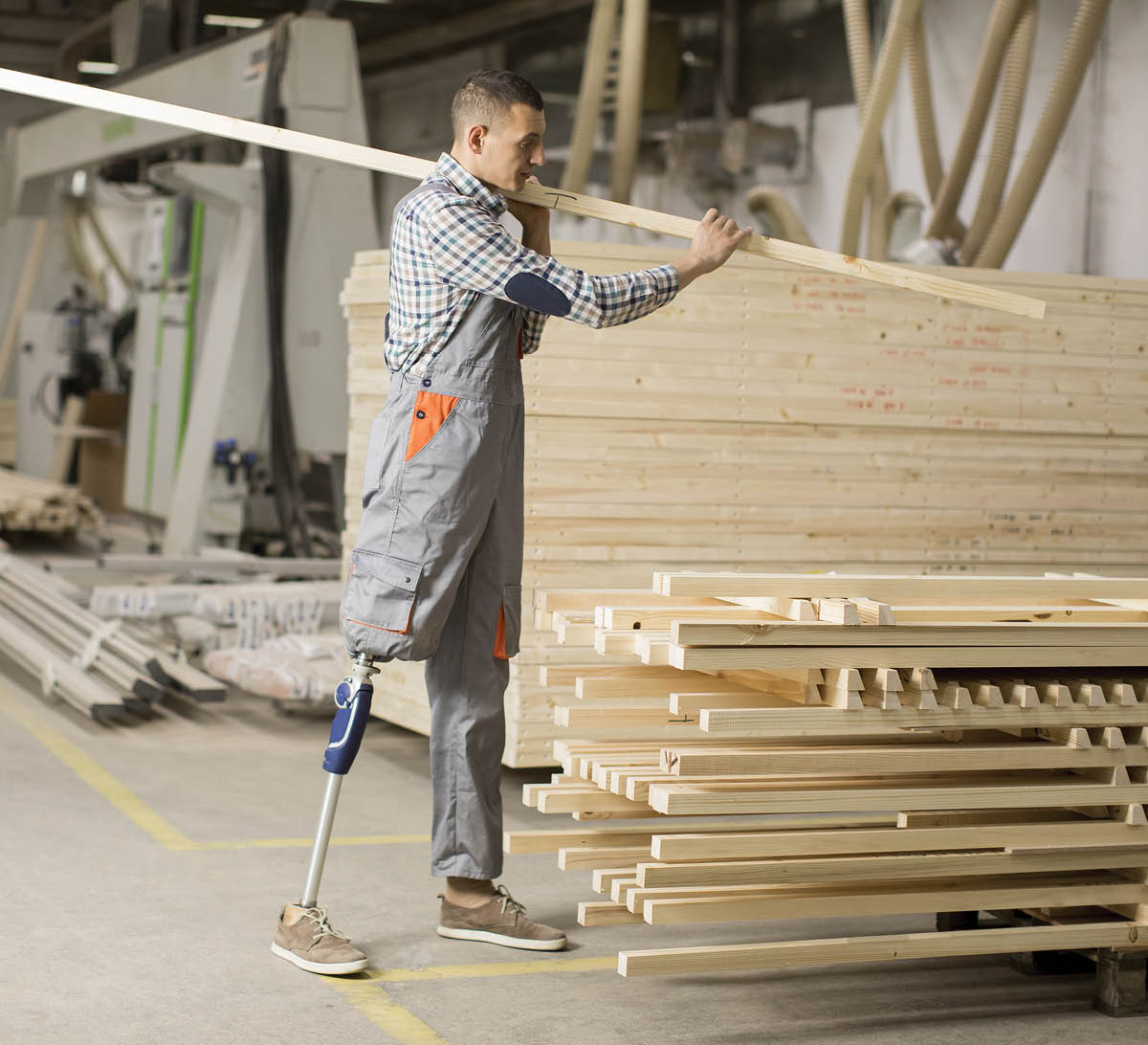 man with prosthetic leg working in lumber yard