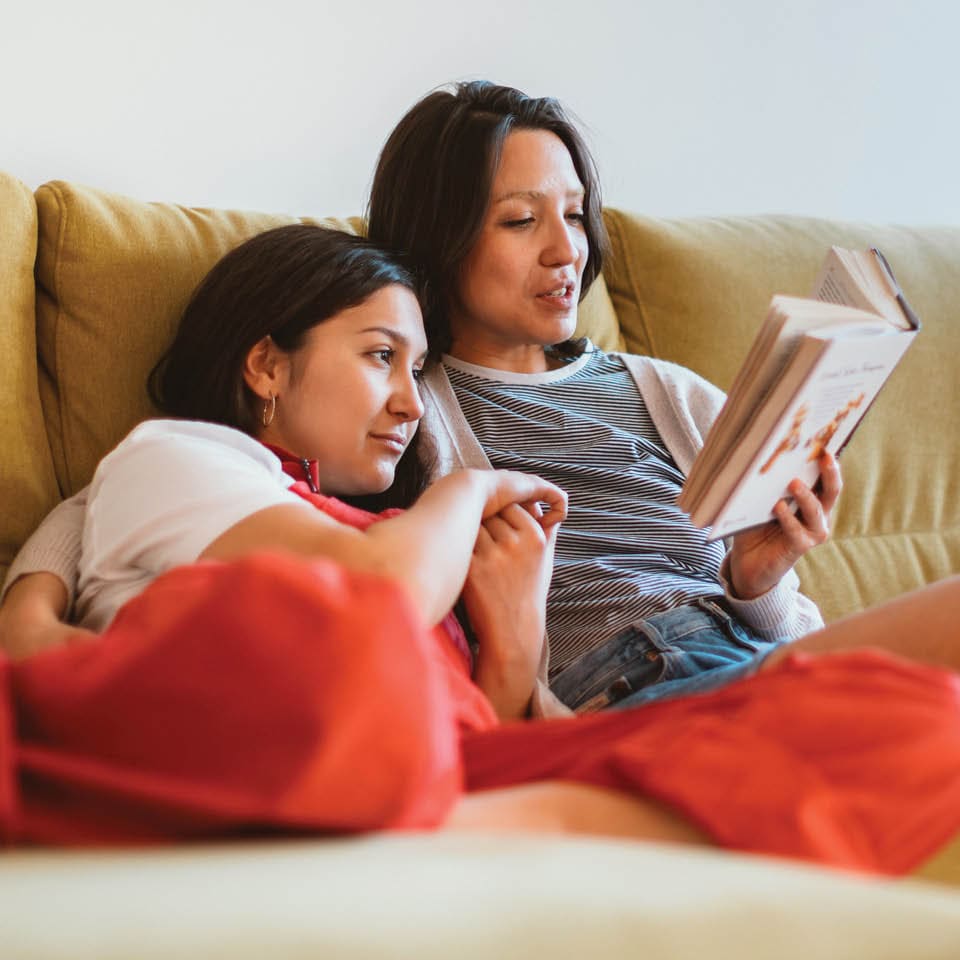 mother and daughter reading a book together