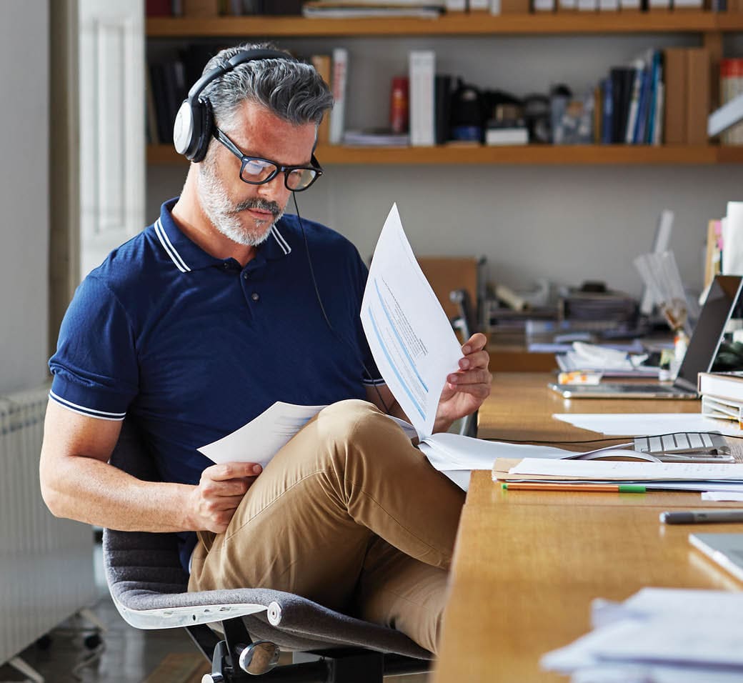 Mature businessman examining documents at desk in office