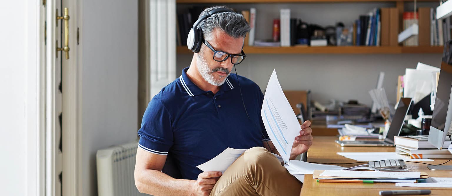 Mature businessman examining documents at desk in office