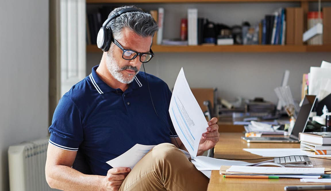 Mature businessman examining documents at desk in office