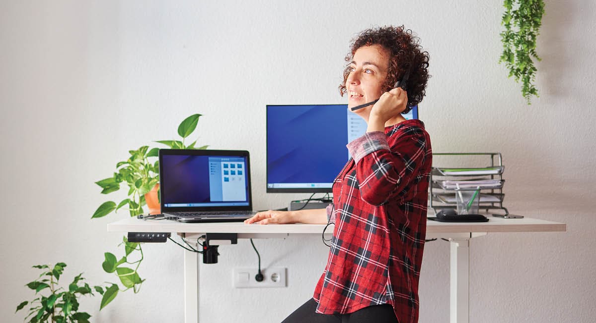 woman working in home office and talking on headset phone