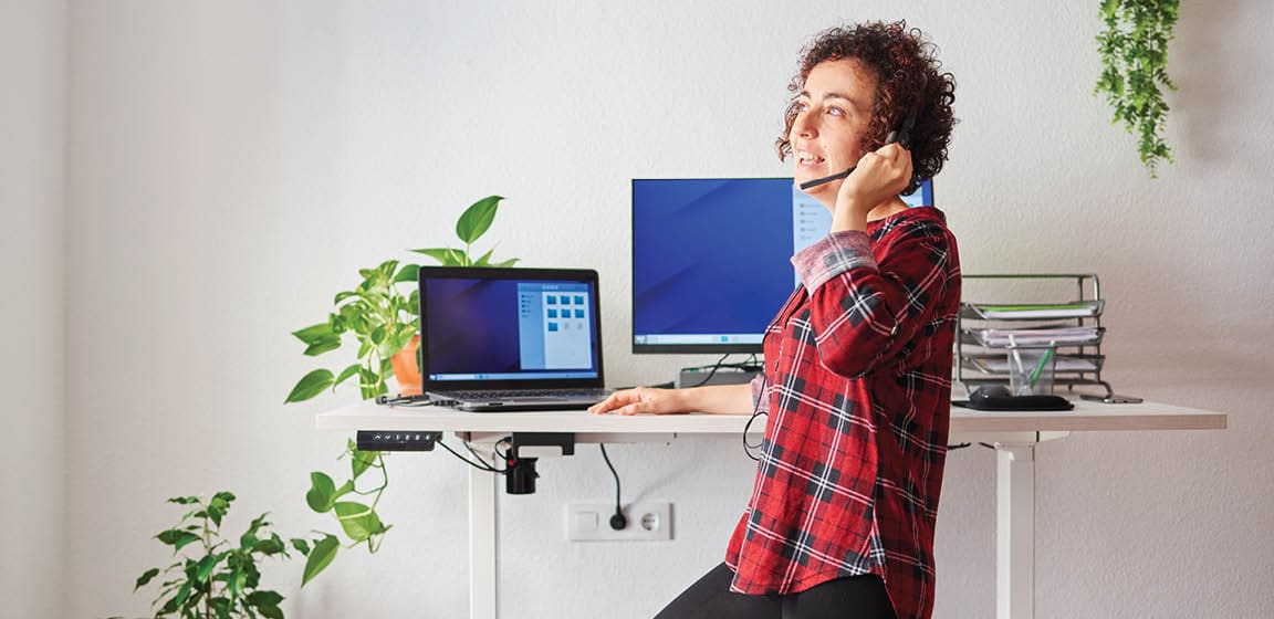 woman working in home office and talking on headset phone