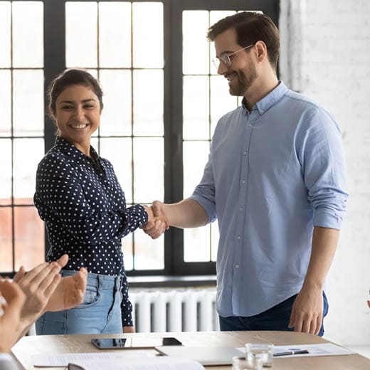 A man and woman shaking hands in a business meeting