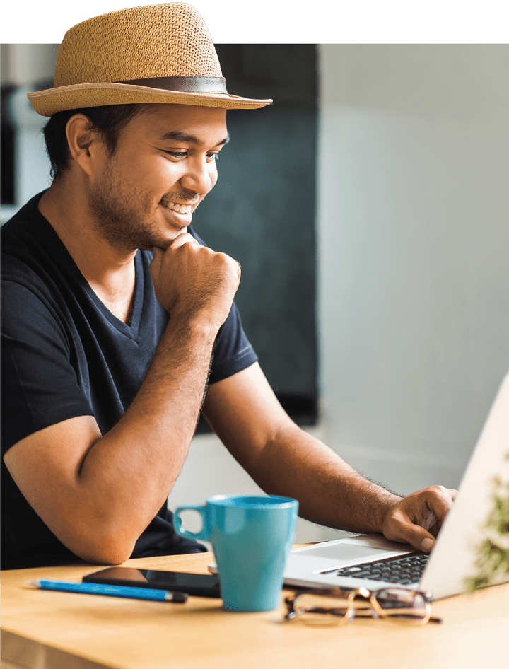 A man in his mid-twenties looking at a computer