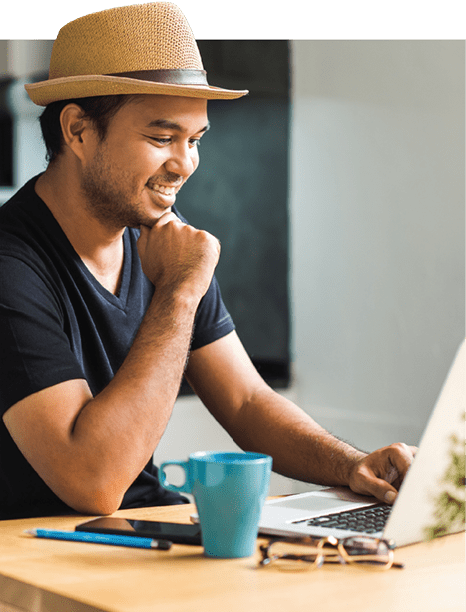 A man in his mid-twenties looking at a computer