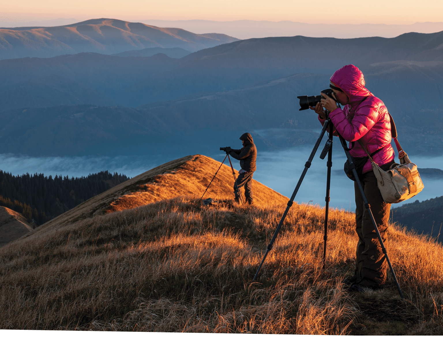 Landscape photographers with the tripods on the mountain top early in the morning. Creating exclusive photo content. Artists at work.