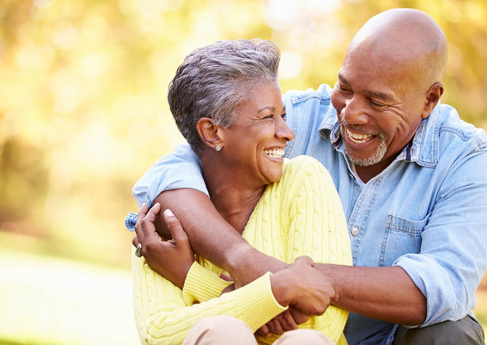laughing older couple with arms around each other