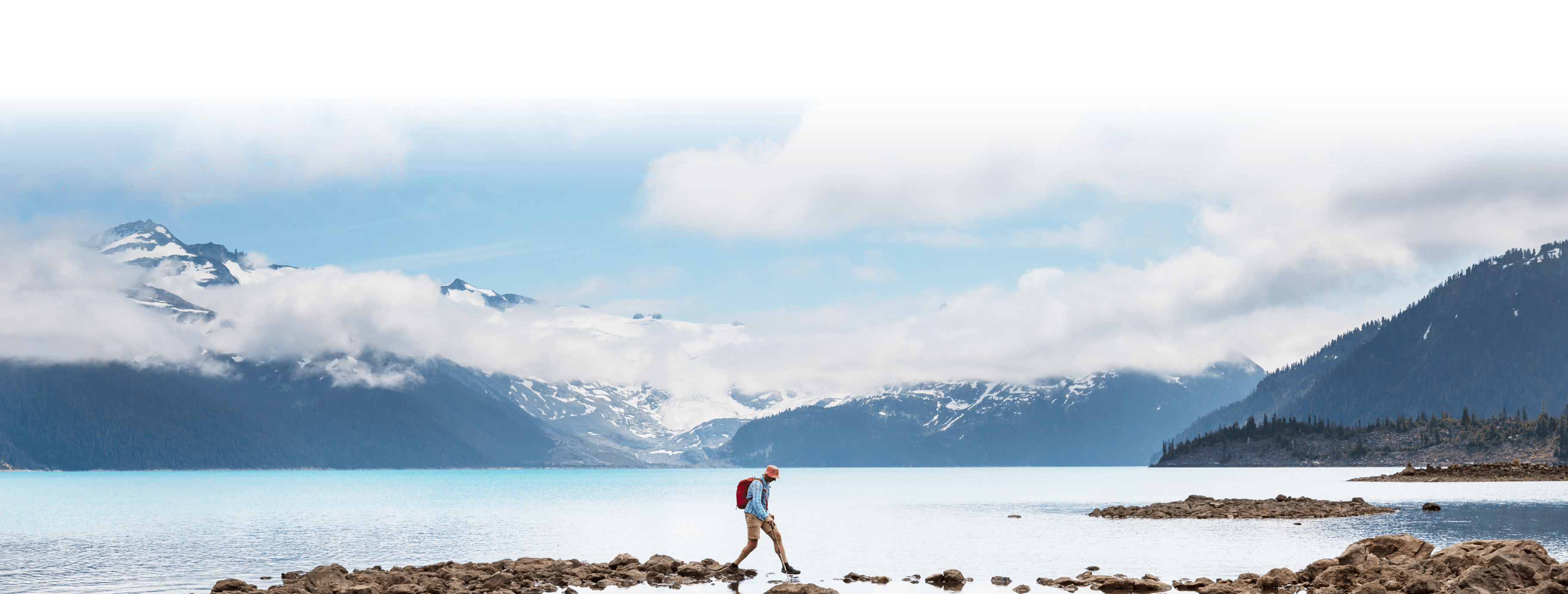 hiker walking on exposed rocks to cross water