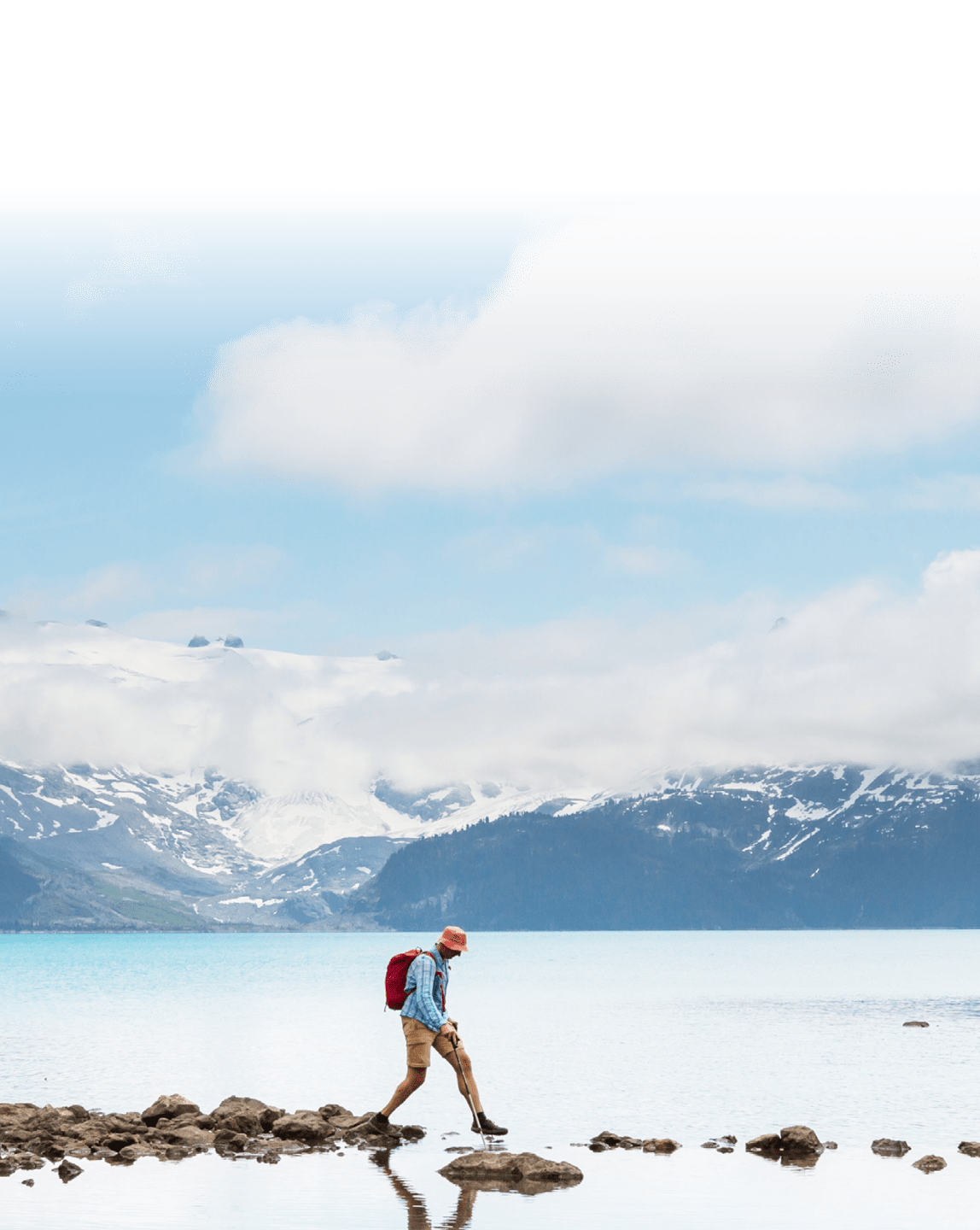 hiker walking on exposed rocks to cross water