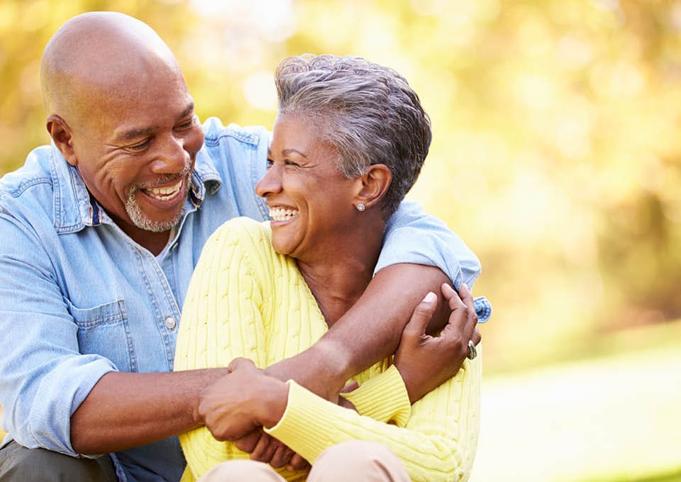 laughing older couple with arms around each other