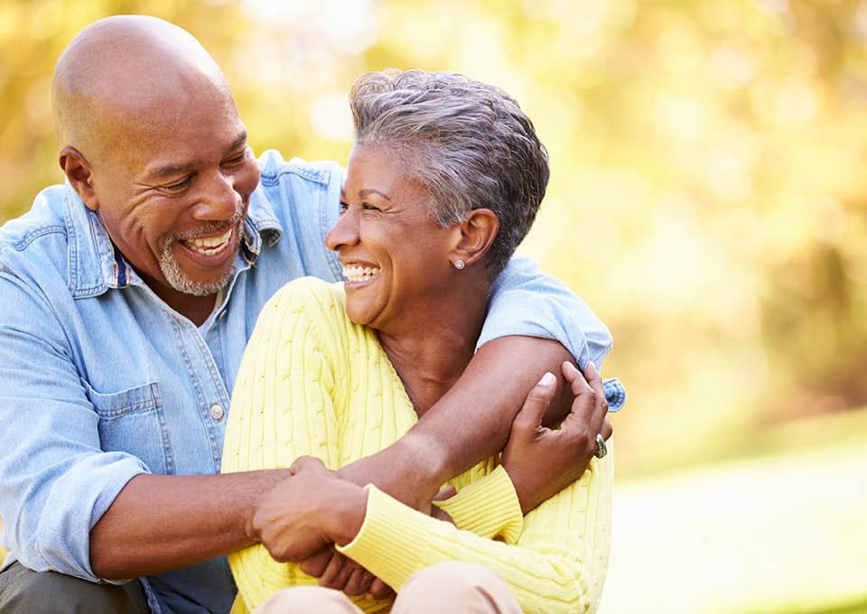 laughing older couple with arms around each other