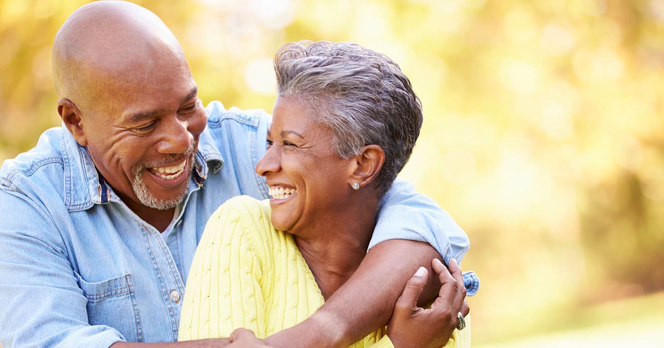 laughing older couple with arms around each other