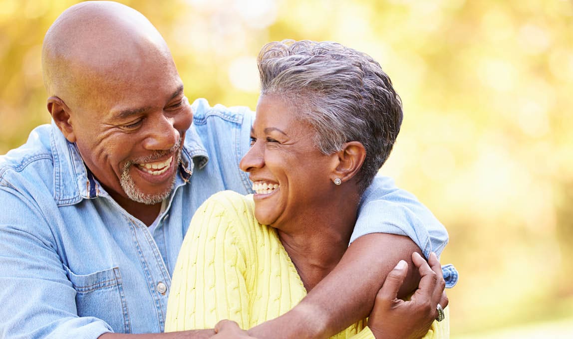 laughing older couple with arms around each other