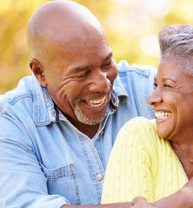 laughing older couple with arms around each other