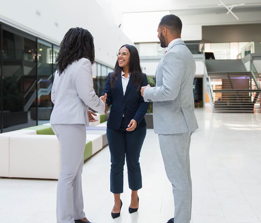 Woman in a business suit meeting with a man and another woman in suits