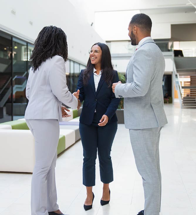 Woman in a business suit meeting with a man and another woman in suits